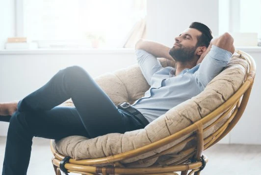 Entspannt wechseln Mann hockt entspannt im Sessel